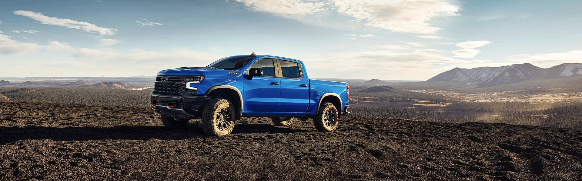 Blue Chevrolet Silverado pickup on a dirt trail, the kind of off-road driving Trail Boss and Z71 trucks are built for near Tavares, FL